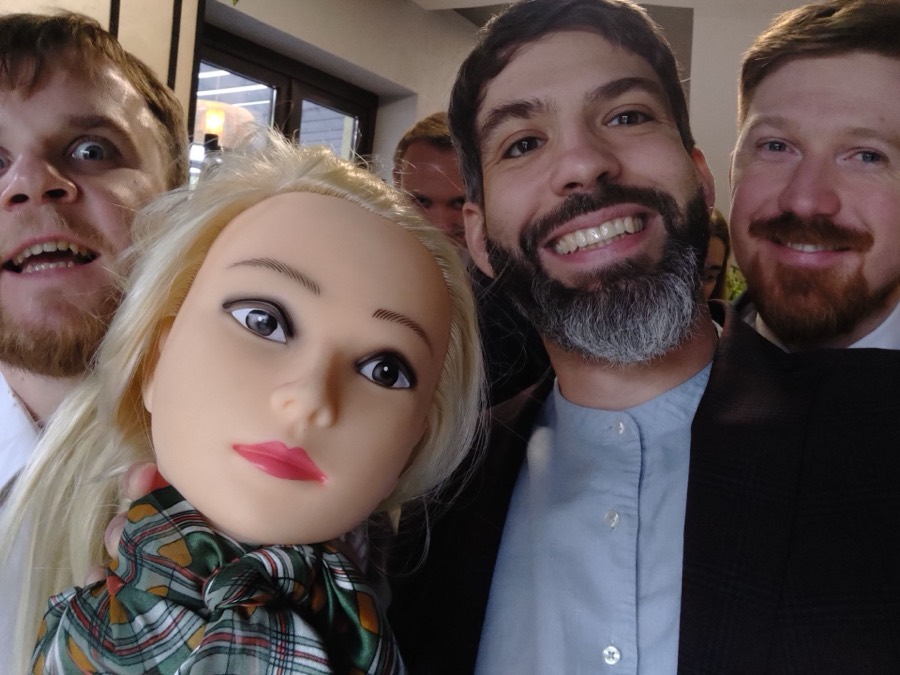 Grupowe selfie gości weselnych z lalką